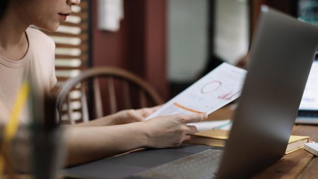 Business woman working in finance and accounting Analyse financial budget at home.