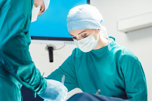 Team of surgeons in operation room during surgery from low angle view