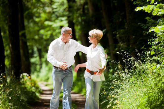 Mature or senior couple deeply in love chasing each other in late spring or early summer