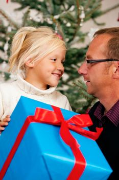 Young girl receives a gift by her father
