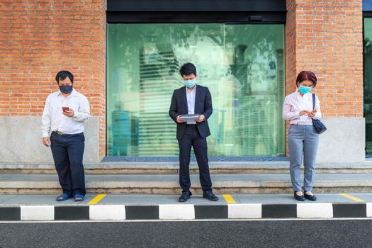 Asian middle aged people wearing mask and keep social distancing to avoid the spread of COVID-19