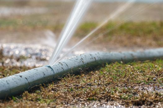 water leaking from hole in a agriculture hose.