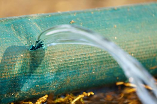 water leaking from hole in a industrial hose.