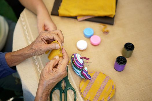 Elderly woman with caregiver in the needle crafts occupational therapy  for Alzheimer’s or dementia