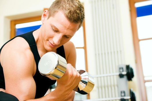 Man having a workout with dumbbell in the gym