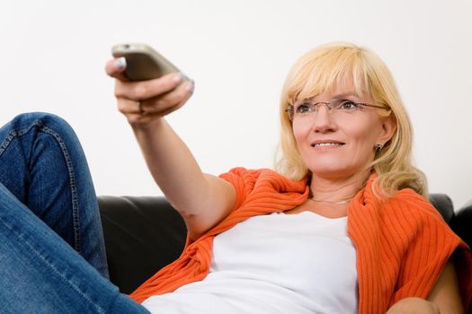 Woman on a sofa with a tv remote control (focus on face)