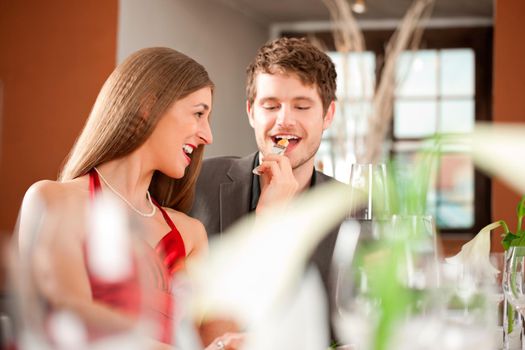 Cheerful couple enjoying meal at restaurant