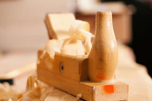 Used wood planer in the workshop of a carpenter with shavings of wood, standing on a workbench