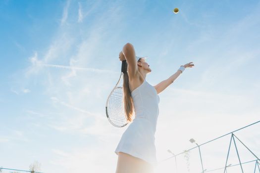 Woman serving the ball for a game of tennis on court