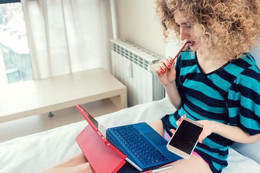 Woman thinking hard working from home sitting on the bed