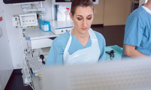 Internal specialist doctor looking at screen mid examination in a modern hospital