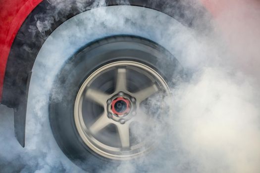 Drag racing car burns rubber off its tires in preparation for the race