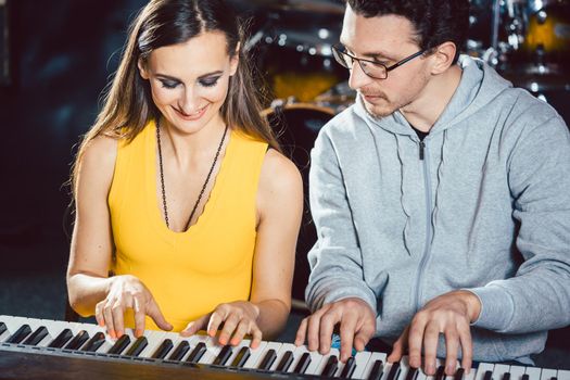 Piano players playing together four-handed piece during music school rehearsal