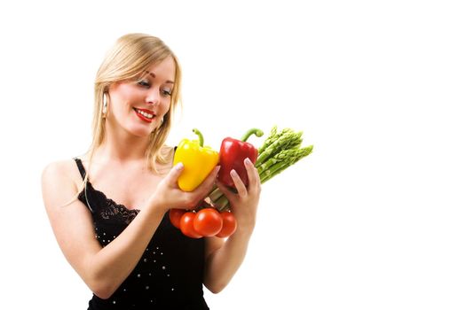 Blonde girl looking at vegetables in her hands, metaphor for healthy and nutritious food