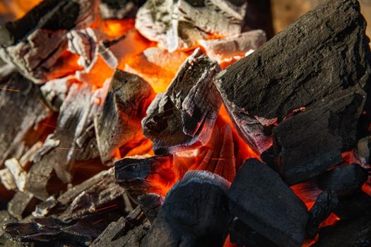 Close up of charcoal is starting to burn in the kitchen grill.  Hot charcoal and flame with smoke.