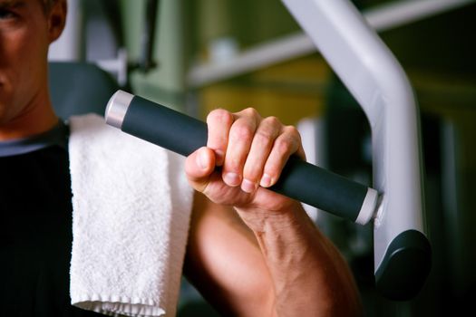 Man lifting weights in a gym, closeup on his hand