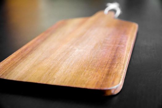 Wooden cutting board on black table background