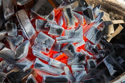 Close up of charcoal is starting to burn in the kitchen grill.  Hot charcoal and flame with smoke.