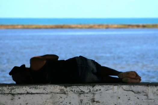 porto Seguro, bahia / barazil - august 25, 2008: homeless person is seen detaito next to a breakwater in the city of Porto Seguro, in the south of Bahia.
