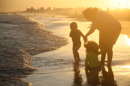 salvador, bahia / brazil - february 26, 2018: woman is seen playing with children on Pituacu beach in the city of salvado