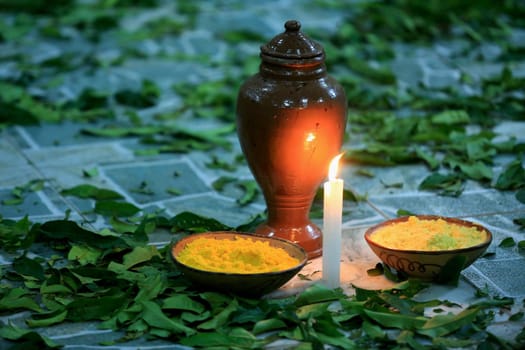 simoes filho, bahia / brazil - february 27, 2016: lighted candle is seen in a Candomble yard next to floured sacred leaves of religion.