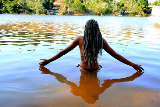 mata de sao joao, bahia, brazil - september 30, 2020: young black man is seen bathing in Arua lagoon, on the coast of the city of Mata de Sao Joao.
