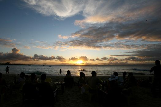 marau, bahia / brazil - december 27, 2011: people are seen during sunset at Baia de Camamu in the district of Barra Grande.