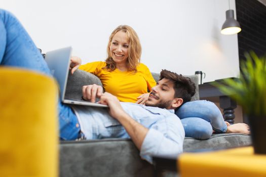 boy lying with laptop on girlfriend's lap