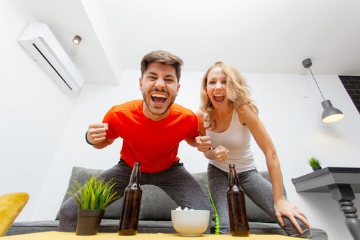 couple with beer bottles cheering and screaming