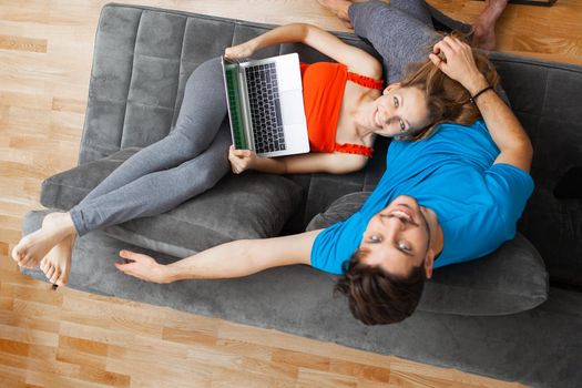 girl lying with laptop on boyfriend's lap