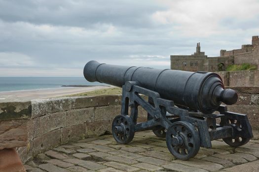 BAMBURGH, NORTHUMBERLAND, ENGLAND, UK - SEPTEMBER 10, 2017: Old Iron Cannon at Bamburgh Castle on Northumberland Coast of England, UK.