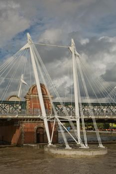 LONDON, UK - SEPTEMBER 08, 2017: View of the Golden Jubilee Bridges and Charing Cross Station from the South Shore of the River Thames in London on a cloudy Summer day.