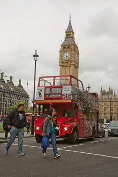 LONDON, UK - SEPTEMBER 08, 2017: People visiting London in UK with iconic old red double decker and Big Ben in the background.