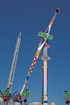 WEYMOUTH, DORSET, ENGLAND, UK - AUGUST 15, 2017: Carousel in amusement park in Weymouth in UK. People enjoying adrenaline and fun. Beautiful weather, bright blue sky
