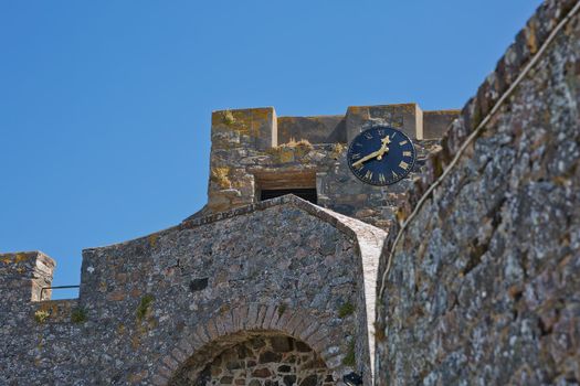 ST. PETER PORT, GUERNSEY, UK - AUGUST 16, 2017: A Clock on the walls of Castle Cornet in St Peter Port, Guernsey, UK.
