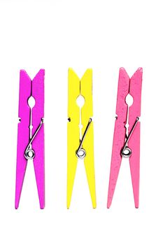 purple, yellow and pink clothes pegs isolated on white background