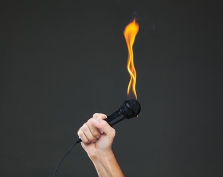 hand holding a microphone on fire