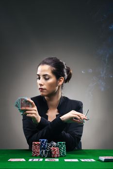 girl playing poker with lots of chips and a cigar