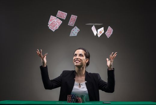 Girl playing poker. Throwing cards in the air.