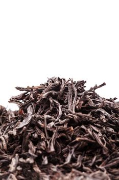 pile of black tea leaves against white backgorund