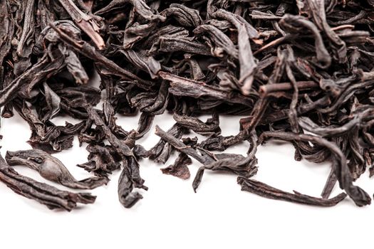 pile of black tea leaves against white backgorund