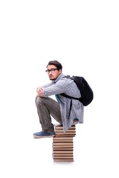 Young student sitting on top of book stack on white