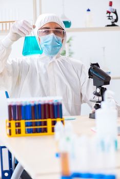 Young chemist student working in lab on chemicals
