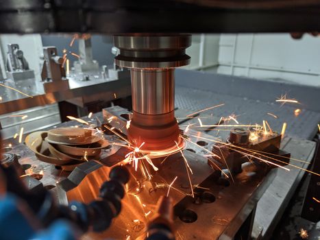 cnc milling of hardened steel with sparks - closeup with selective focus and blur.