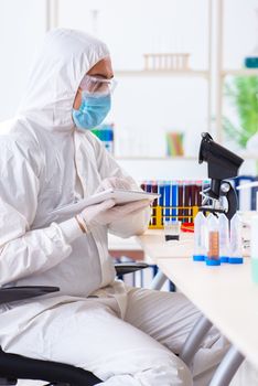 Young chemist student working in lab on chemicals