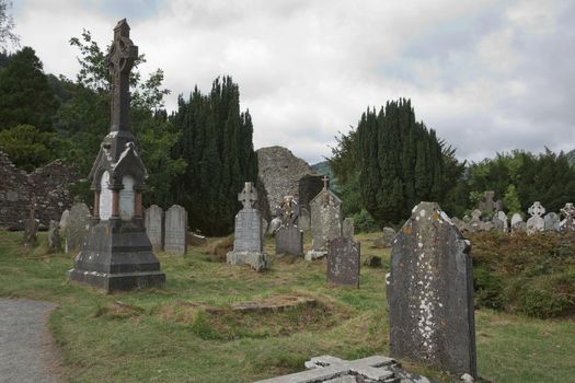 Glendalough, co. Wicklow, Ireland - August 10 2019 :Stone round tower and some ruins of a monastic settlement originally built in the 6th century in Glendalough valley, County Wicklow, Ireland.