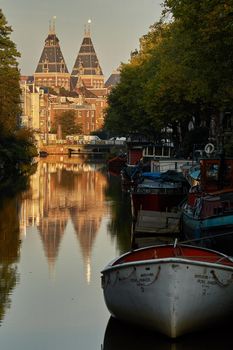AMSTERDAM, NETHERLANDS - SEPTEMBER 21, 2017: One of the churches of Amsterdam in Netherlands, unique with city scene along canal in morning natural light.