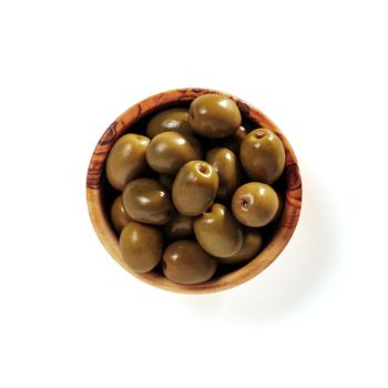 Small wooden bowl with green olives isolated on white background. Flat lay or top view of small beautiful olive tree bowl with full green olives, isolated with clipping path