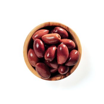 Small wooden bowl with red kalmata olives isolated on white background. Flat lay or top view of small beautiful olive tree bowl with full red olives, isolated with clipping path