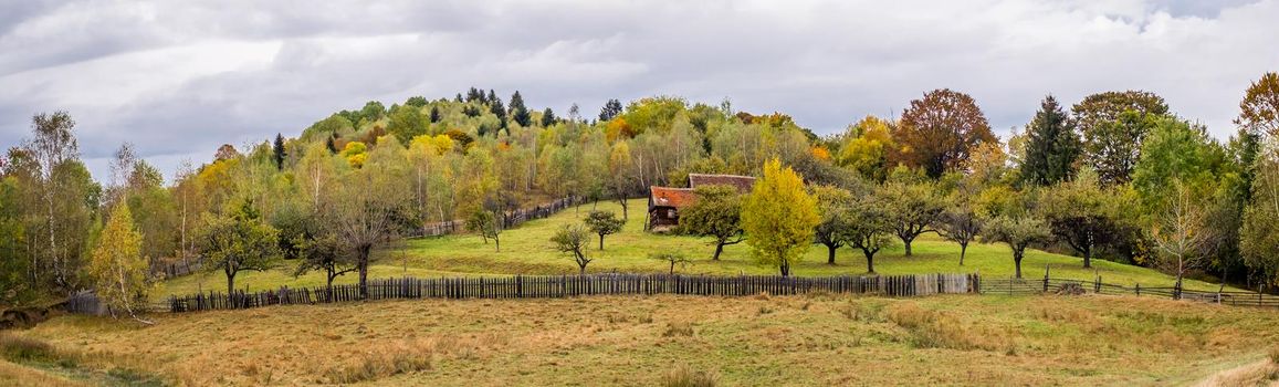 a cottage surrounded by a fence in an atmosphere of autumn, Fantanele village, Sibiu county, Romania